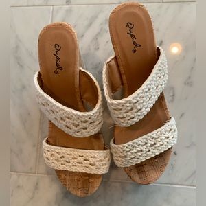 Crocheted white wedge sandals.
